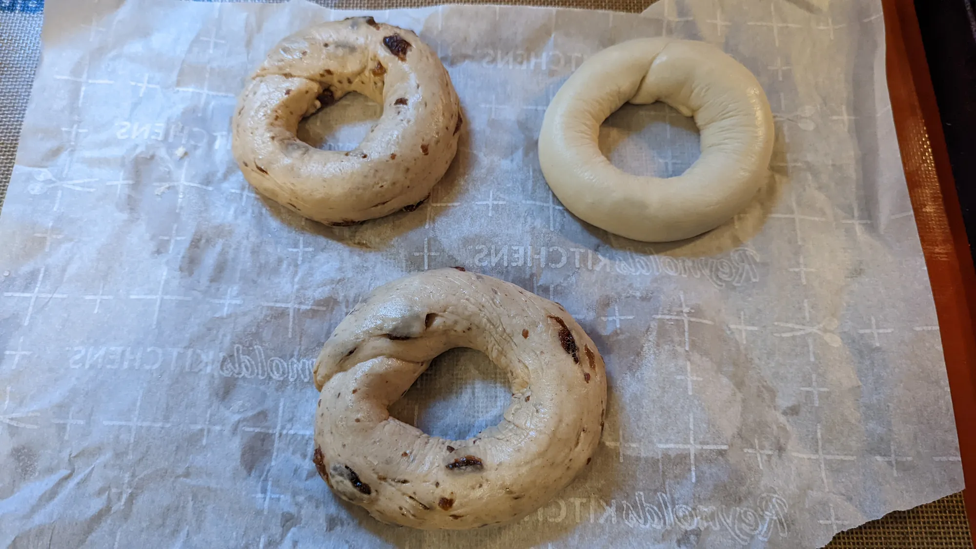 Two cinnamon-raisin and one plain bagel, shaped but not yet baked.